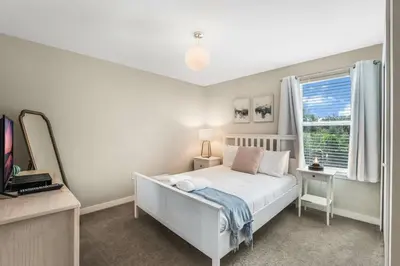 a bedroom with a white bed and a window at Cozy home in the best location of orlando in Kissimmee
