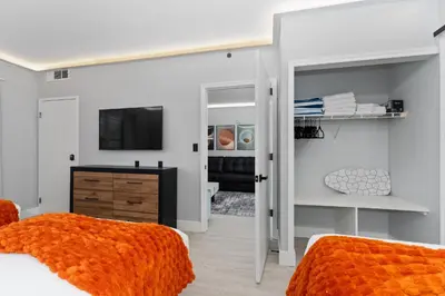 a bedroom with two beds with an orange blanket at Spacious 1BR near Universal I-Drive in Orlando