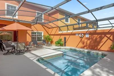 a pool with chairs and a table and a building at Upstay Family Home w Resort Access & Private Pool in Kissimmee