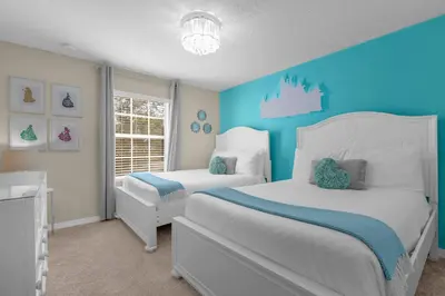 a bedroom with two beds and a blue wall at Upstay Family Home w Resort Access & Private Pool in Kissimmee