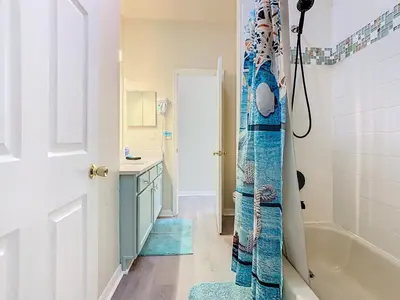 a bathroom with a tub and a sink and a shower at 4BR home w pool, spa & BBQ grill in Orlando