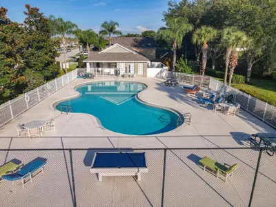an overhead view of a swimming pool with chairs and a fence at 4BR home w pool, spa & BBQ grill in Orlando