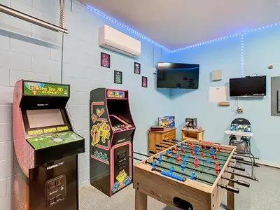 a room with two arcade games and a game table at 4BR home w pool, spa & BBQ grill in Orlando