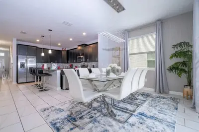 a dining room and kitchen with a table and chairs at Villa 6Q Storey Lake – 10 min da Disney in Kissimmee