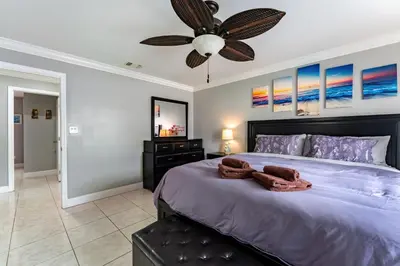 a bedroom with a large bed with a ceiling fan at 9 min to Disney Entrance-Peaceful Single Family House in Kissimmee