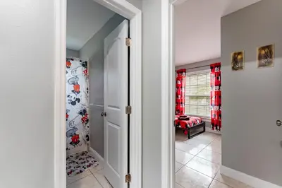 a home hallway with a walk in closet with red curtains at 9 min to Disney Entrance-Peaceful Single Family House in Kissimmee