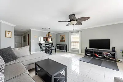 a living room with a couch and a flat screen tv at 9 min to Disney Entrance-Peaceful Single Family House in Kissimmee