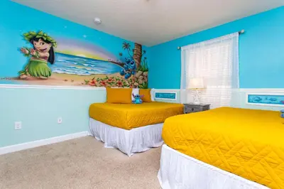 two beds in a room with a disney painting on the wall at Wonderful 4Bd with Pool at Storey Lake Resort 4819 in Kissimmee