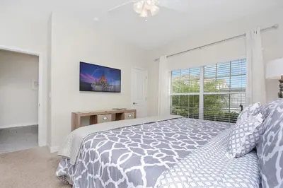 a white bedroom with a bed and a window at Wonderful 4Bd with Pool at Storey Lake Resort 4819 in Kissimmee