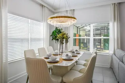 a dining room with a table and chairs and a chandelier at Refúgio 5 Quartos c/ Piscina – Perto da Disney in Kissimmee