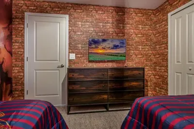 a bedroom with a brick wall and a dresser at Refúgio 5 Quartos c/ Piscina – Perto da Disney in Kissimmee