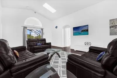 a living room with two leather couches and a table at Cozy 5BR Near Disney Mickey Pool in Kissimmee
