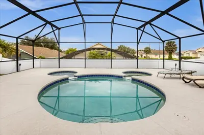 a large swimming pool with a glass roof at Cozy 5BR Near Disney Mickey Pool in Kissimmee