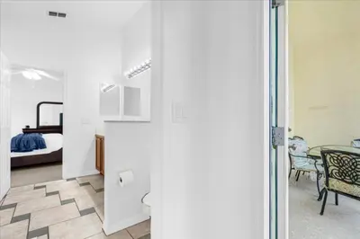 a room with a bedroom and a bed with a table at Cozy 5BR Near Disney Mickey Pool in Kissimmee