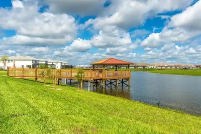 a dock with a gazebo next to a body of water at Apartamento 2Q | 10 Min da Disney | Piscina in Kissimmee