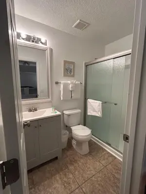 a bathroom with a toilet and a sink and a shower at Lovely Vacation Home with 3 bedrooms! in Kissimmee