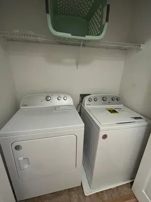 a small laundry room with a washer and dryer at Lovely Vacation Home with 3 bedrooms! in Kissimmee