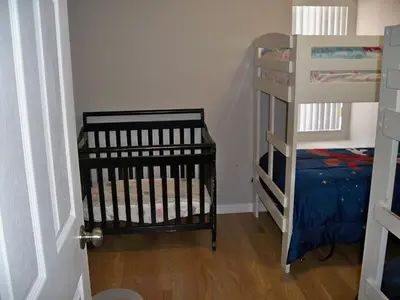 a bedroom with a crib and a bunk bed at Lovely Vacation Home with 3 bedrooms! in Kissimmee