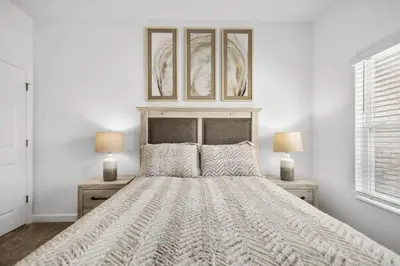 a white bedroom with a large bed with two lamps at NEW King Bed Disney Contemporary Townhouse in Kissimmee