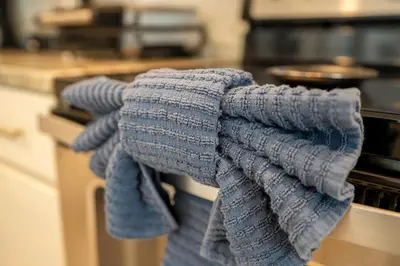 a pile of towels hanging from an oven in a kitchen at Fantastic 5BR Villa Near Disney - Priv. Pool SPA in Orlando
