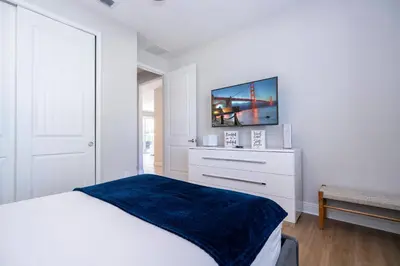 a white bedroom with a bed with a blue blanket at Fantastic 5BR Villa Near Disney - Priv. Pool SPA in Orlando