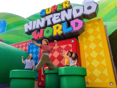 a woman jumping in front of a inflatable kindergarten world at NEW King Bed Glow In The Dark Kid Cave in Kissimmee