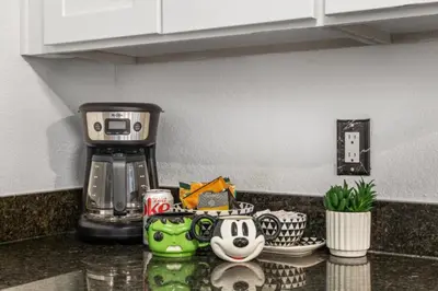 a kitchen counter with a coffee maker on top of it at NEW London House Orlando Airport Private Condo in Orlando