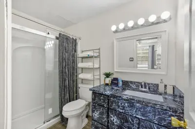 a bathroom with a toilet and a sink and a mirror at NEW London House Orlando Airport Private Condo in Orlando