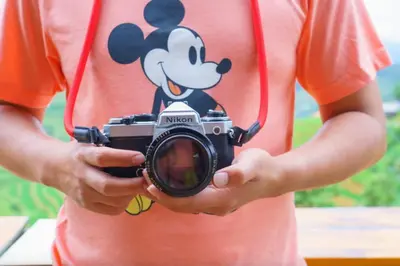 a person holding a camera with a mickey mouse shirt at NEW London House Orlando Airport Private Condo in Orlando