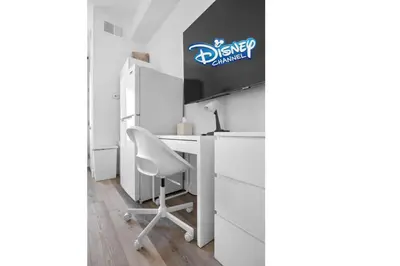 a desk with a chair and a sign on a wall at King Bed Theme Park Hotel Free Shuttle Included in Orlando