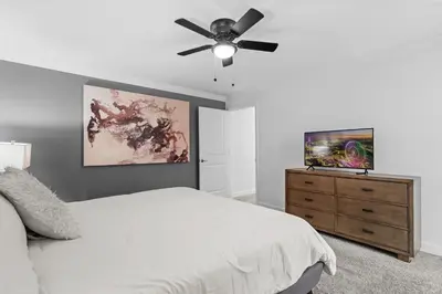 a bedroom with a bed and a ceiling fan at Stylish 4BR home Near Disney with Themed Rooms in Kissimmee