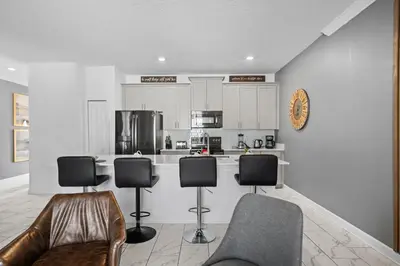a kitchen with four chairs and a counter top at Stylish 4BR home Near Disney with Themed Rooms in Kissimmee