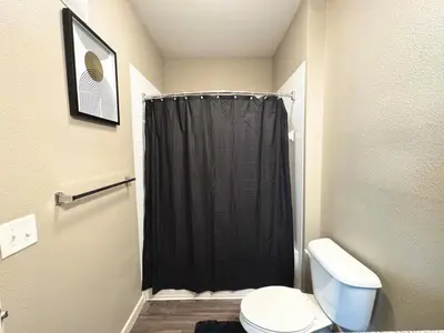 a bathroom with a shower curtain and a toilet at Modern Apt in Lake Nona, 10min to ORL Airport in Orlando