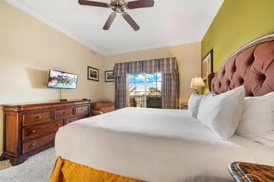 a bedroom with a large bed and a ceiling fan at Villas North Charm in Orlando