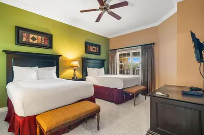 a hotel room with two beds and a television at Villas North Charm in Orlando