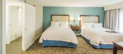 two beds in a hotel room with blue walls at Hampton Inn & Suites Orlando near SeaWorld in Orlando