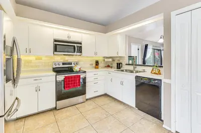 a kitchen with white cabinets and stainless steel appliances at Swim, Golf and Relax Lovely Home in Lake Mary in Lake Mary