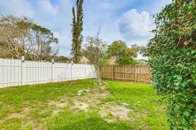 a yard with a fence and a small tree at Swim, Golf and Relax Lovely Home in Lake Mary in Lake Mary