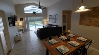 a living room with a table and a couch at Spectacular Lake View - Game Room- Close to Disney in Kissimmee