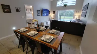 a living room with a wooden table and chairs at Spectacular Lake View - Game Room- Close to Disney in Kissimmee