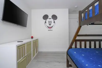 a bedroom with a bunk bed and a flat screen tv at Sunshine Escape 20 minutes from Disney in Kissimmee