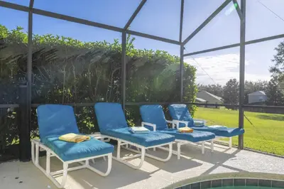 a group of blue chairs sitting on a patio at Sunshine Escape 20 minutes from Disney in Kissimmee