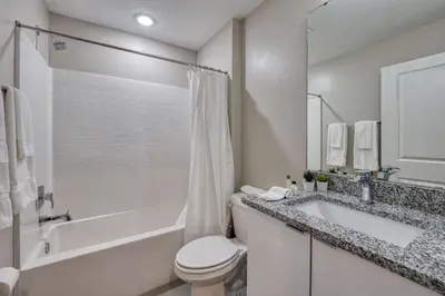 a bathroom with a tub and a toilet and a sink at Luxuosa Villa 4Q c/ Piscina | 10 min da Disney! in Orlando