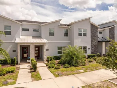 a large white house with a driveway at Stunning 4Bd Close to Disney at Storey Lake Resort 2569 in Kissimmee