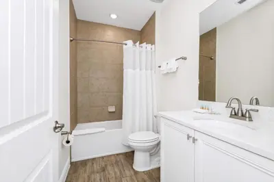 a white bathroom with a toilet and a sink at Coastal Haven Villa Near Disney With Margaritaville Resort & Island H20 Waterpark Access - 2964Or in Orlando