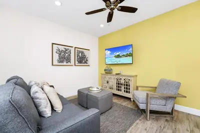 a living room with a couch and a chair at Coastal Haven Villa Near Disney With Margaritaville Resort & Island H20 Waterpark Access - 2964Or in Orlando