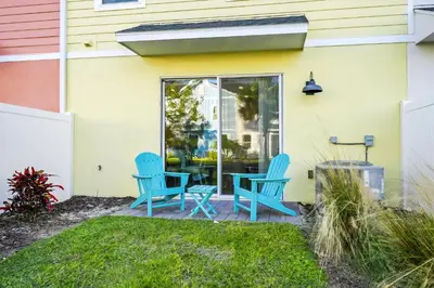 a patio with two blue chairs and a table at Coastal Haven Villa Near Disney With Margaritaville Resort & Island H20 Waterpark Access - 2964Or in Orlando