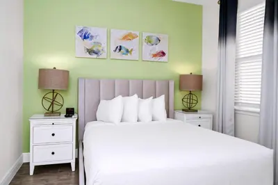 a bedroom with a large white bed with two night stands at Coastal Haven Villa Near Disney With Margaritaville Resort & Island H20 Waterpark Access - 2964Or in Orlando