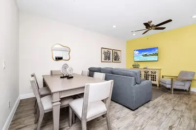 a living room and dining room with a table and a couch at Coastal Haven Villa Near Disney With Margaritaville Resort & Island H20 Waterpark Access - 2964Or in Orlando