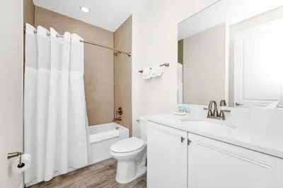 a white bathroom with a toilet and a sink at Tranquil Villa Near Disney With Margaritaville Resort & Island H20 Waterpark Access - 2928Cs in Orlando